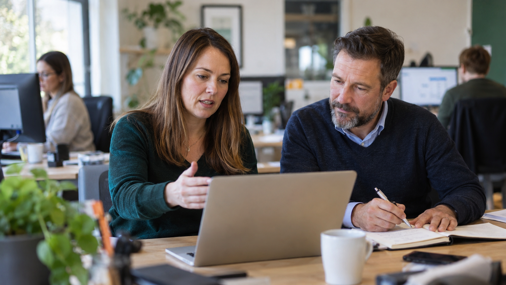 Illustrative workplace photo of sales colleagues reviewing customer accounts together.